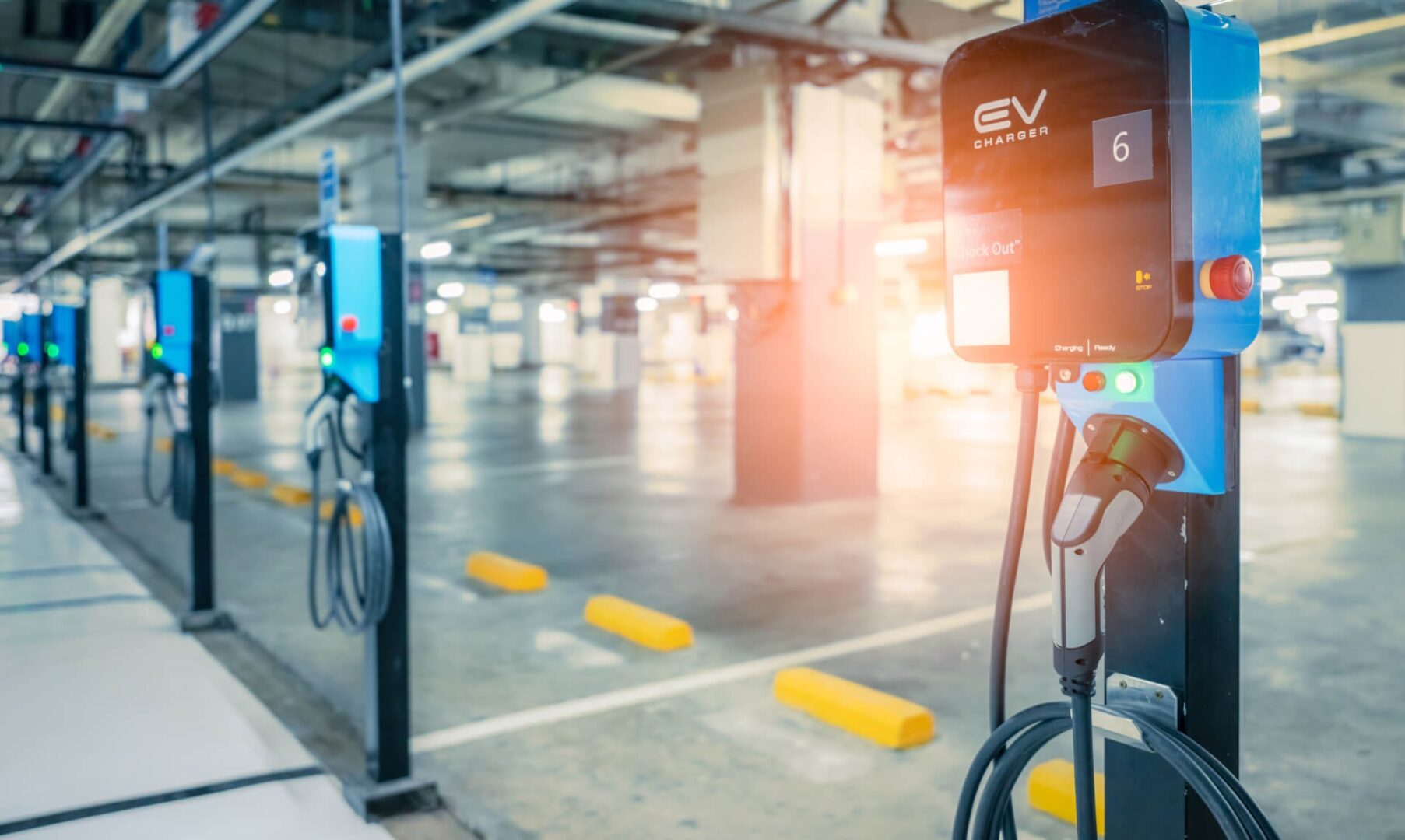 A parking lot with electric cars plugged in.